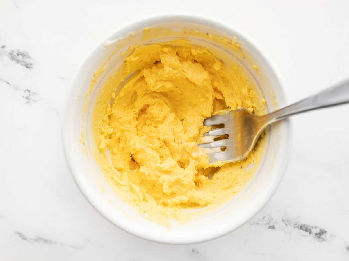 Mashed and seasoned egg yolks in a bowl with a fork