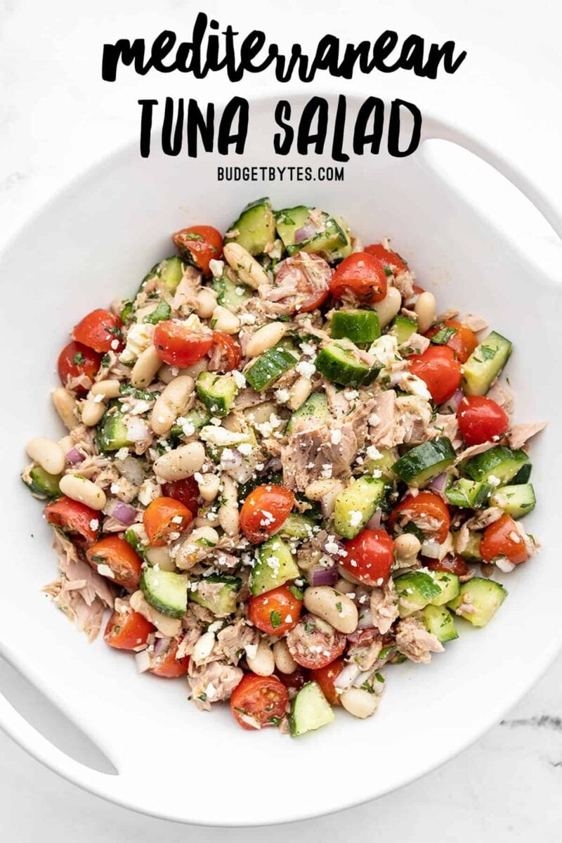 Overhead view of mediterranean tuna salad in a serving dish with title text at the top