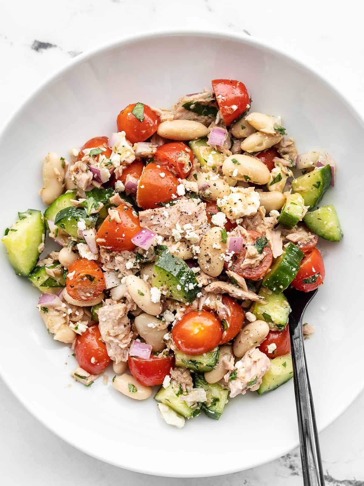 Overhead view of a bowl full of Mediterranean Tuna Salad with a fork in the side