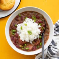 Overhead view of a bowl of quickie red beans and rice with corn muffins on the side