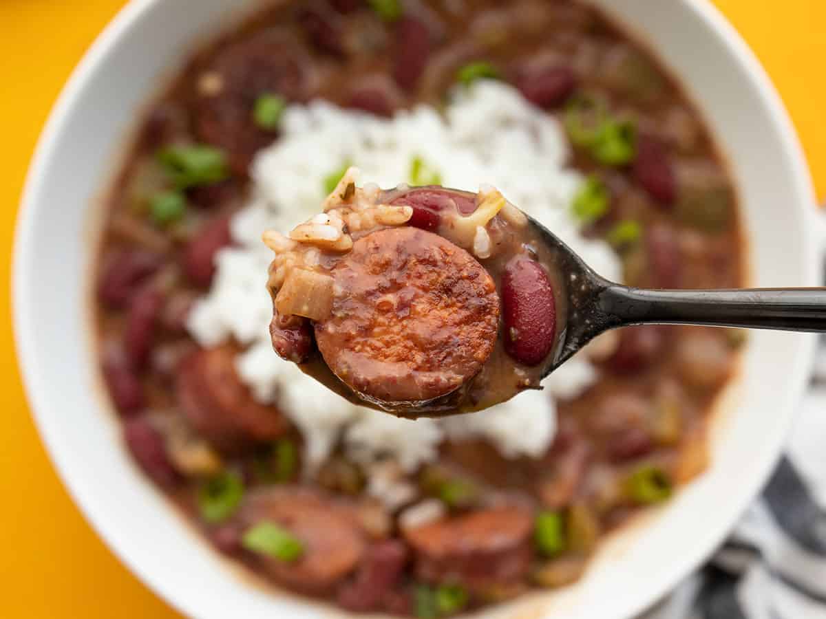 Close up of a spoonful of quickie red beans and rice with the bowl in the background