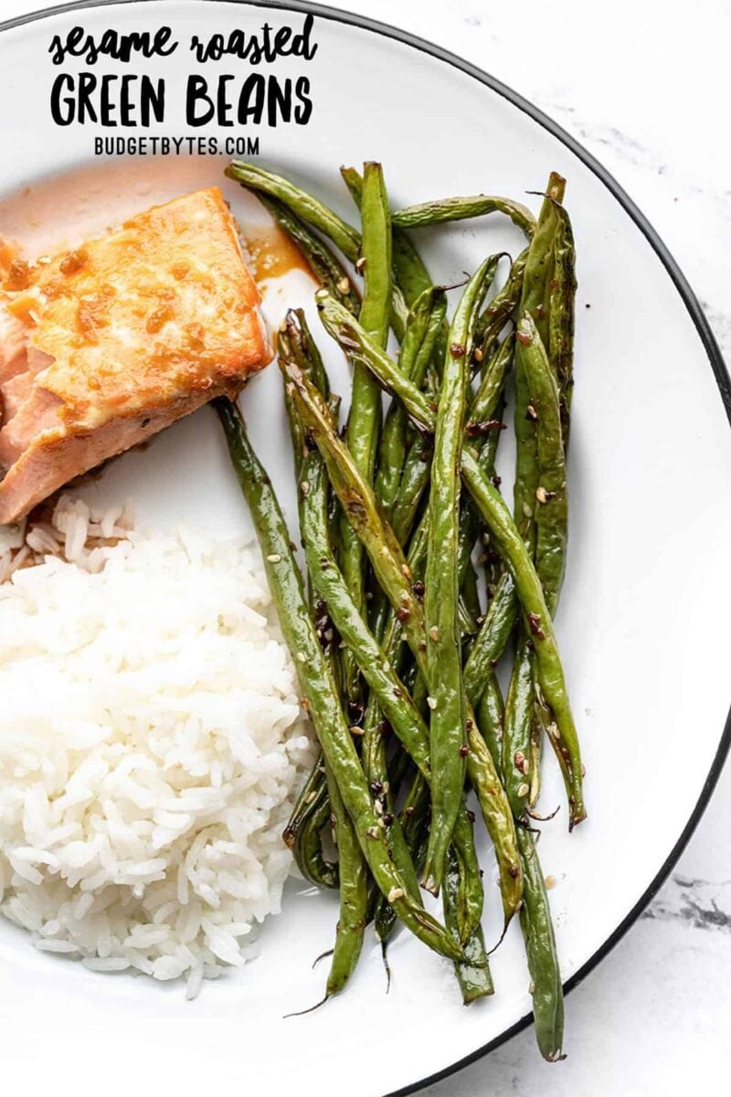 Sesame roasted green beans on a plate with salmon and rice, title text at the top