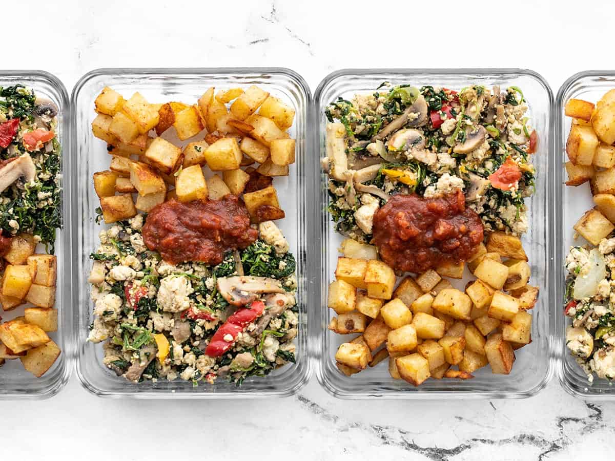 vegetable tofu scramble in glass meal prep containers with roasted potatoes