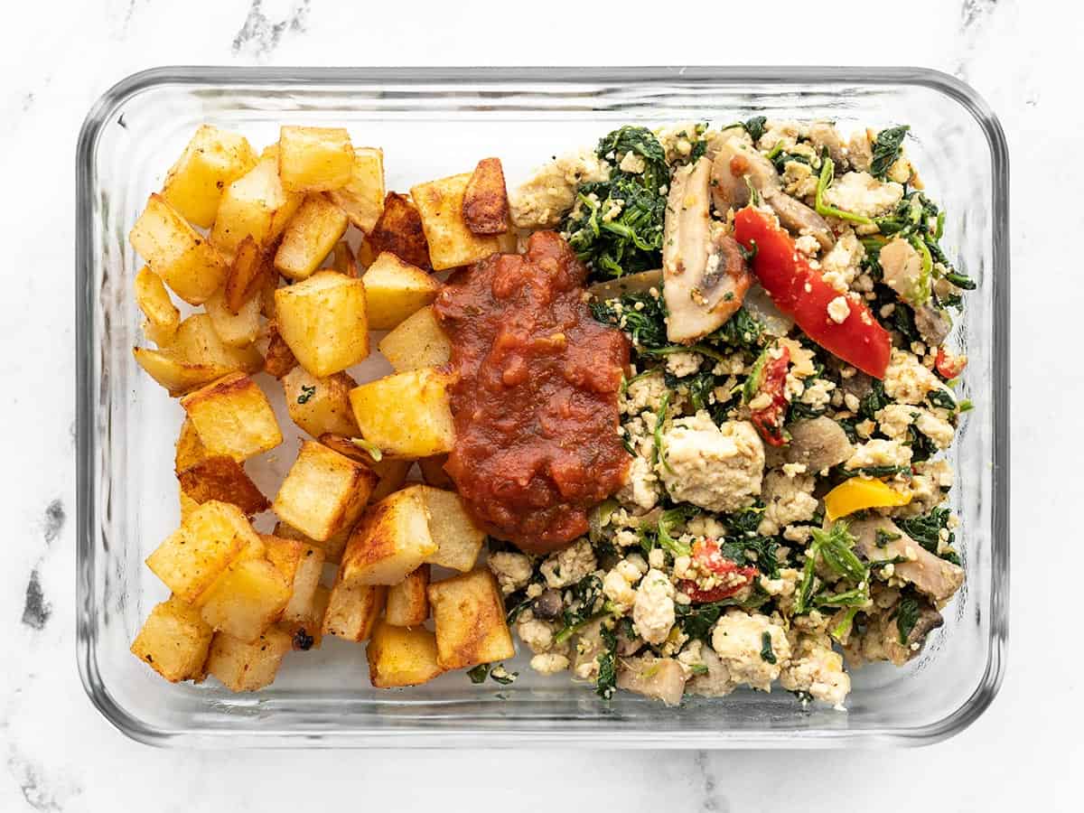 Vegetable tofu scramble in a glass meal prep box with roasted potatoes