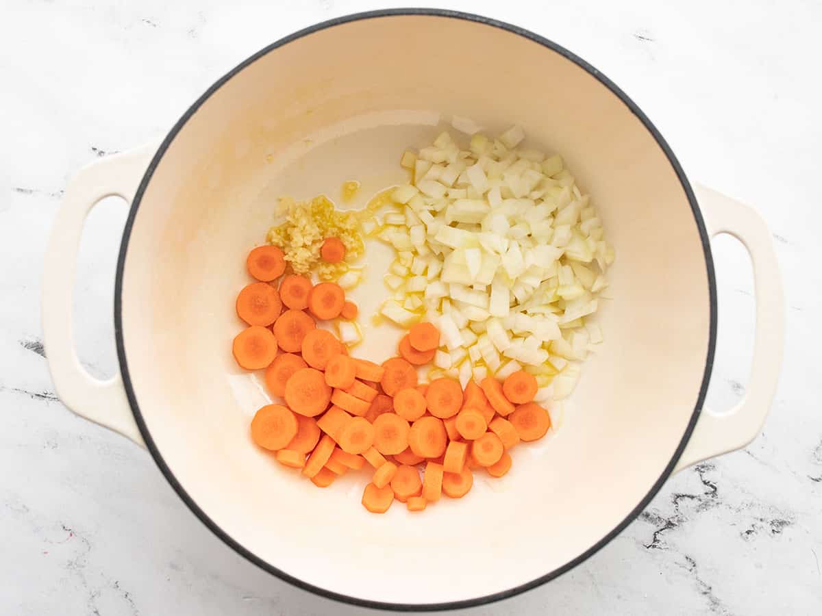 Chopped onion, carrots, and garlic in a soup pot with olive oil