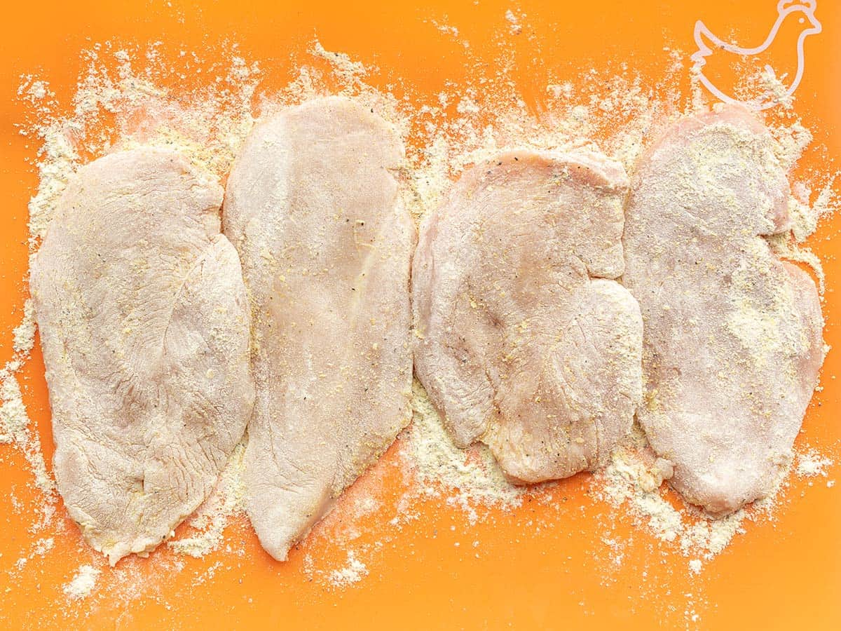 Coated chicken breasts on the cutting board