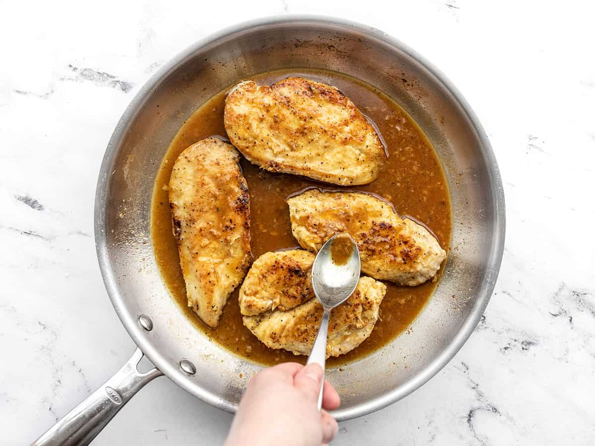 Chicken returned to the skillet, pan sauce being spooned over top