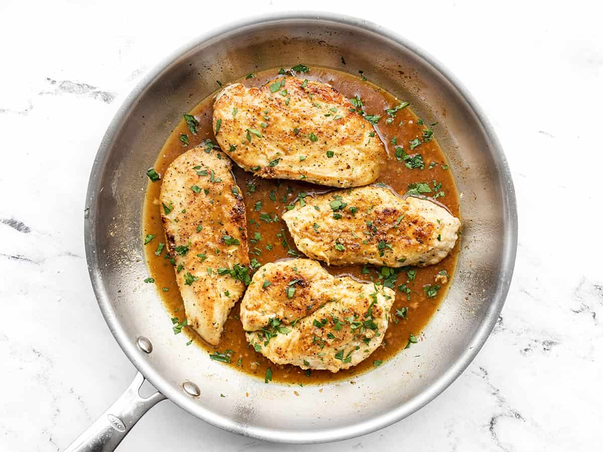 Finished lemon pepper chicken in the skillet topped with parsley