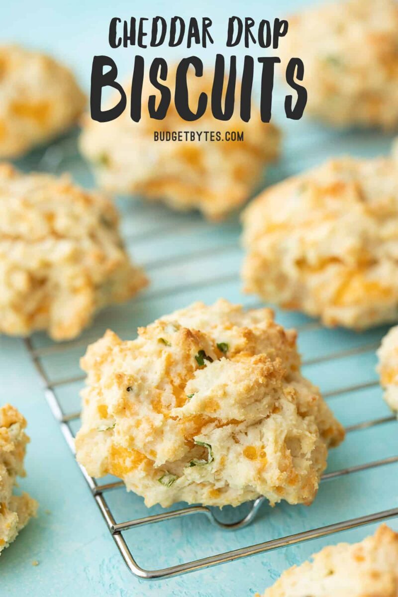 side view of cheddar drop biscuits on the cooling rack, title text at the top