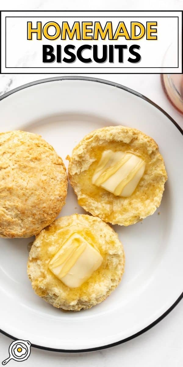 Two biscuits on a plate, one sliced open with butter and honey.
