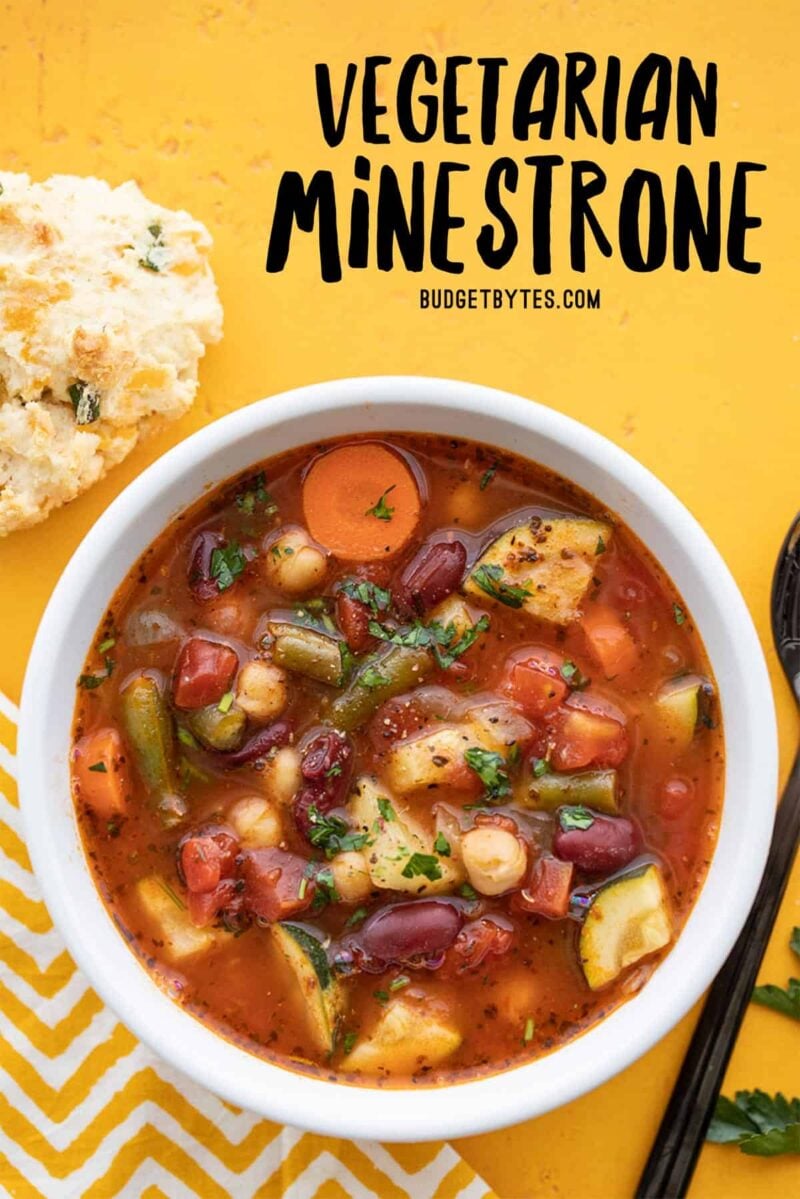 Overhead view of a bowl full of vegetarian minestrone, title text at the top