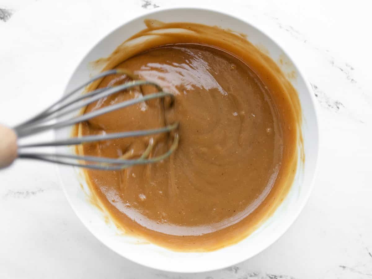 Peanut lime dressing being whisked in a bowl