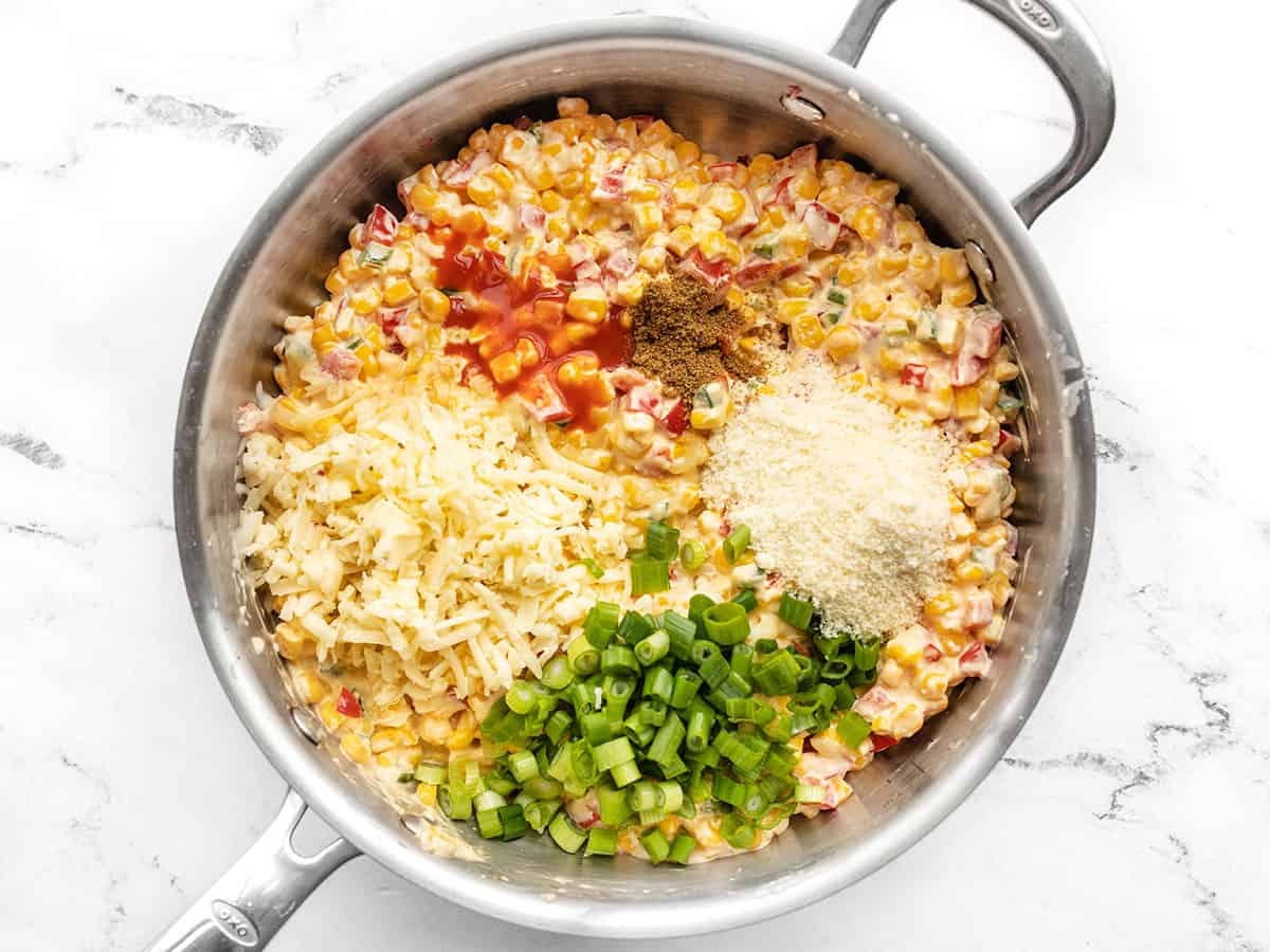 Spices, cheese, and green onion added to the skillet