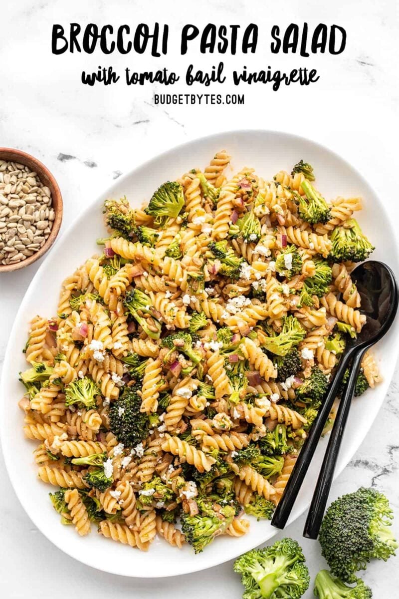 Overhead view of a platter full of broccoli pasta salad, title text at the top