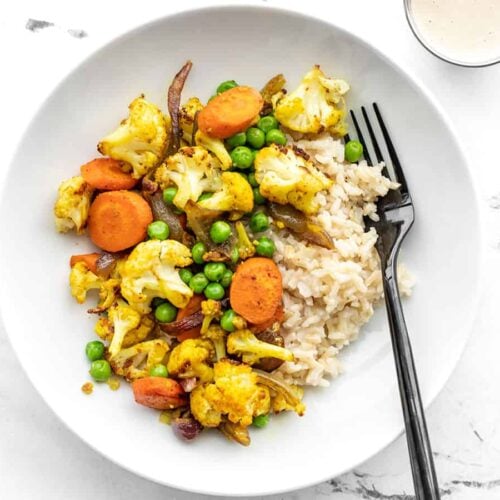 Overview of curry roasted vegetable bowls with lemon tahini dressing on the side