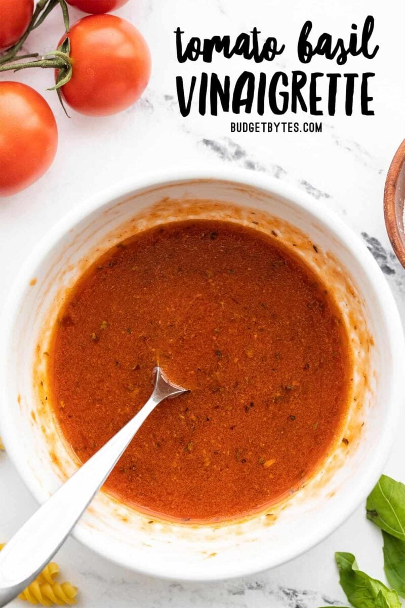 Overhead view of a bowl full of tomato basil vinaigrette, title text at the top