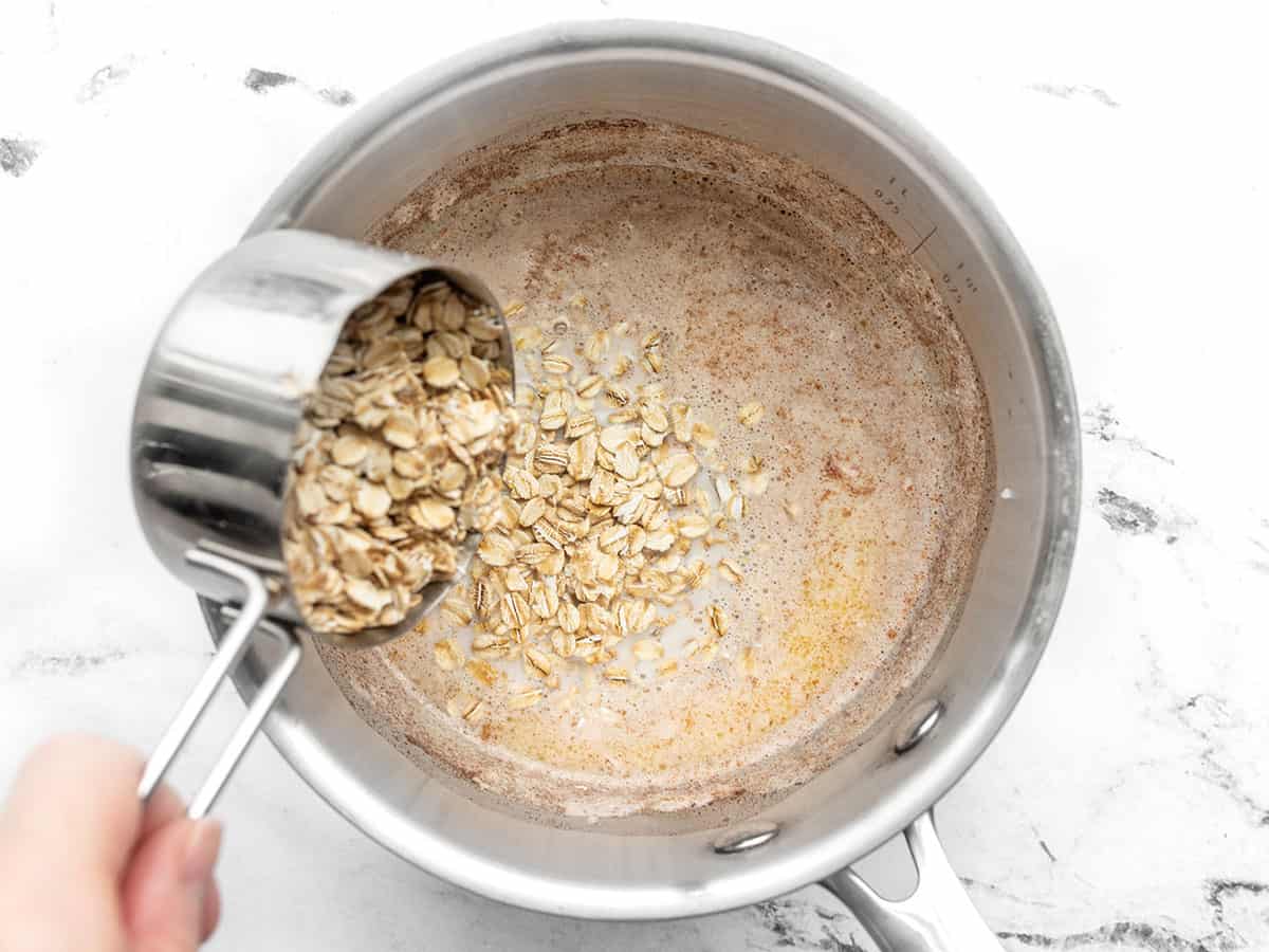 Oats being poured into the saucepot