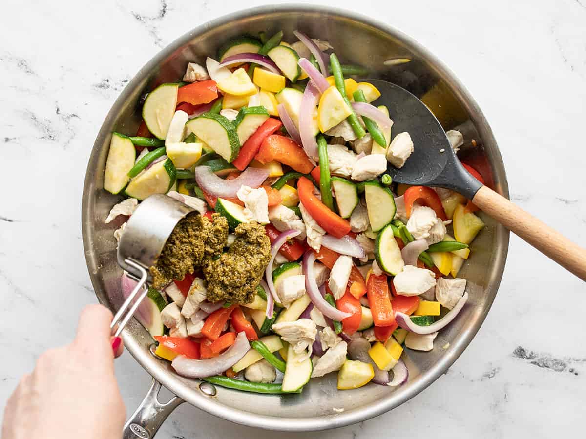 Pesto being added to the skillet