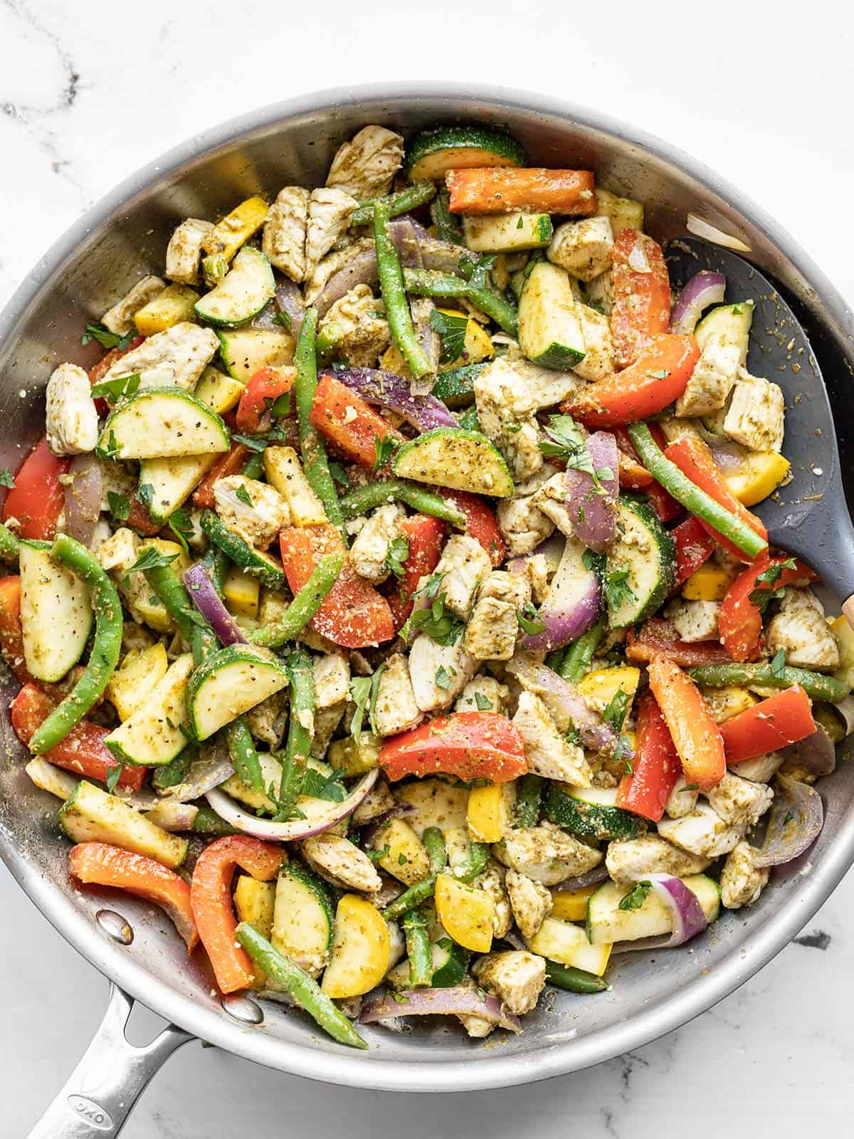 Pesto chicken and vegetables in a skillet
