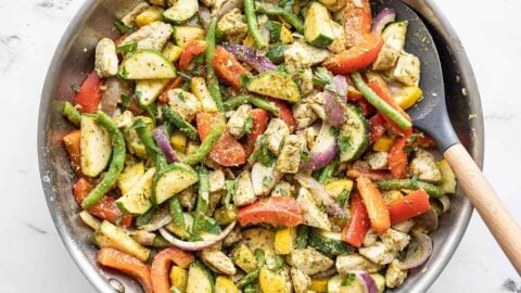 Easy pesto chicken and vegetables in a skillet with a spatula