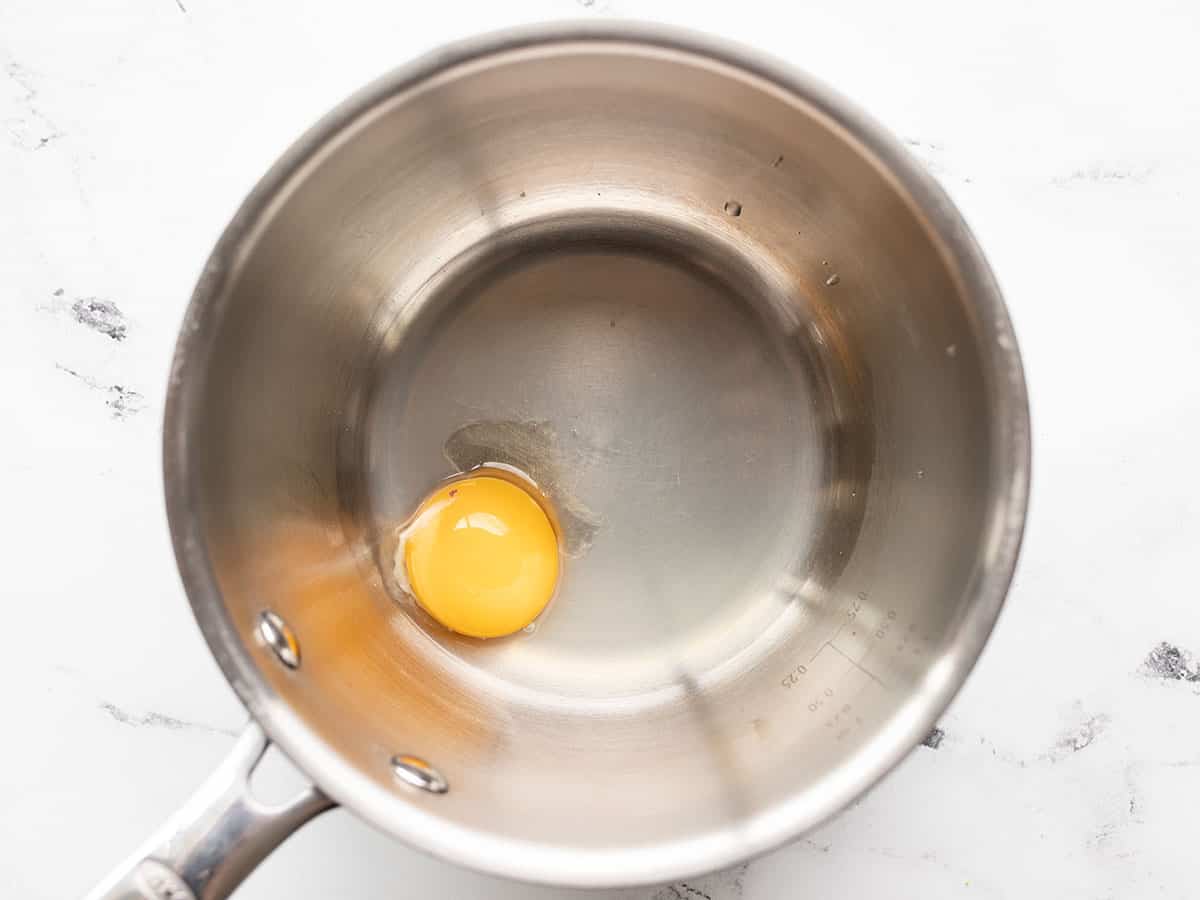 a raw egg yolk in a small saucepot