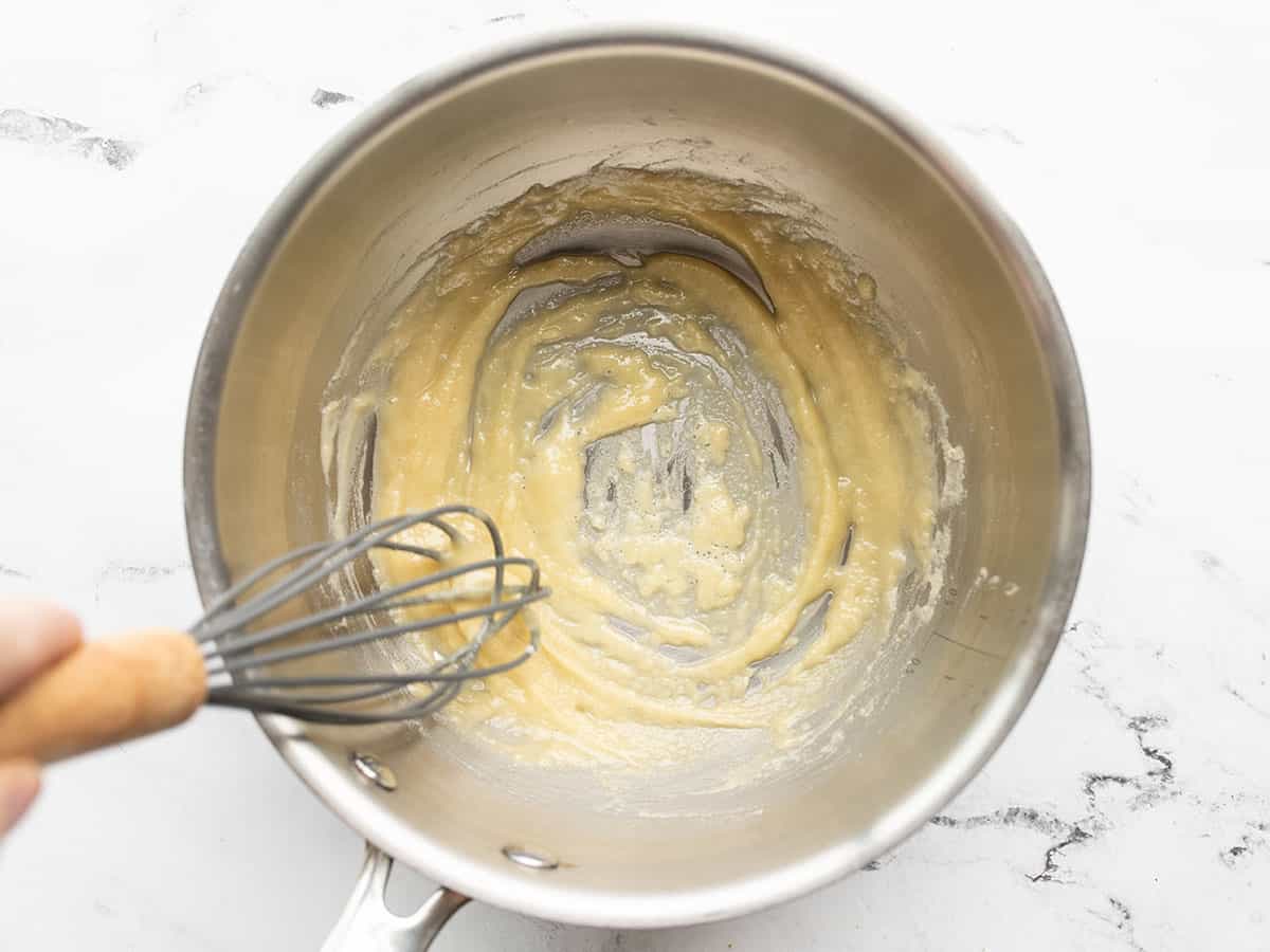 butter and flour being whisked in a saucepot