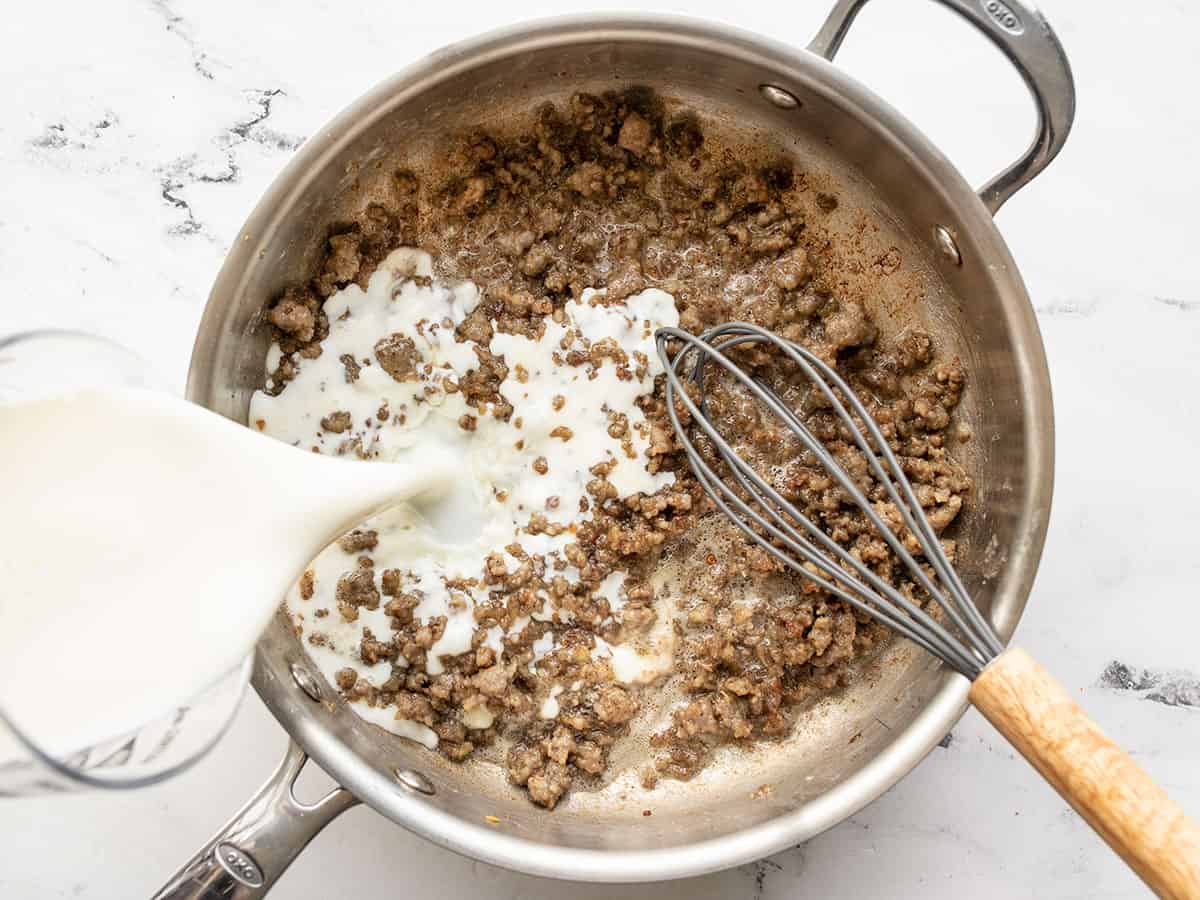 Milk being whisked into the skillet