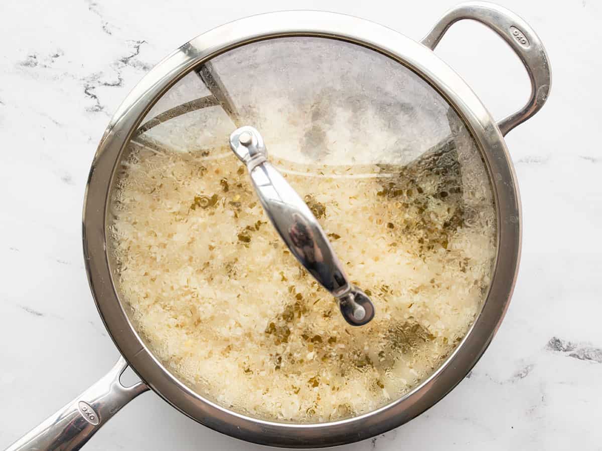 Cooked rice in the skillet with the lid on