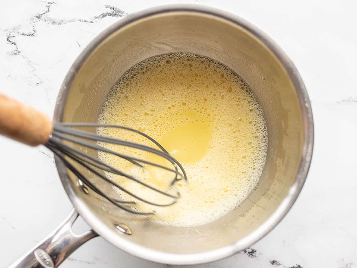 frothy egg mixture in the saucepot with the whisk