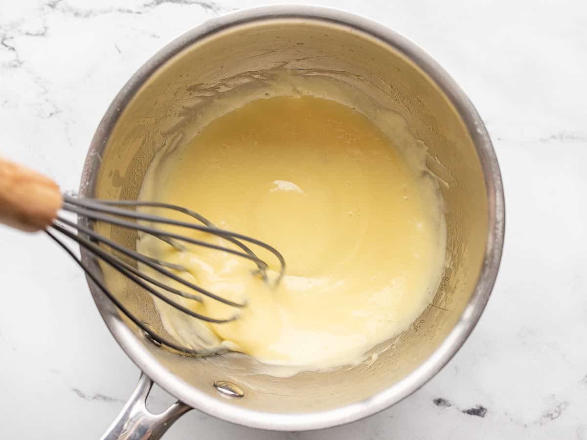 thickened sauce in the sauce pot with a whisk