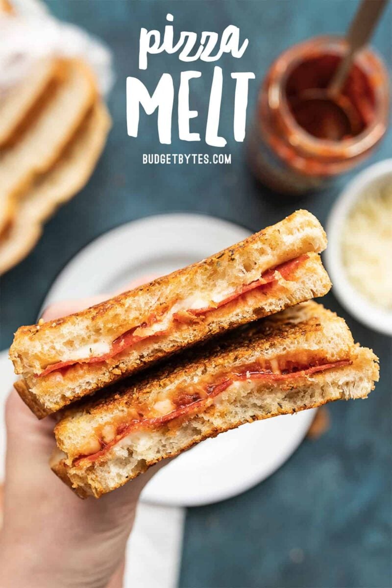 A pizza melt being held close to the camera, title text at the top