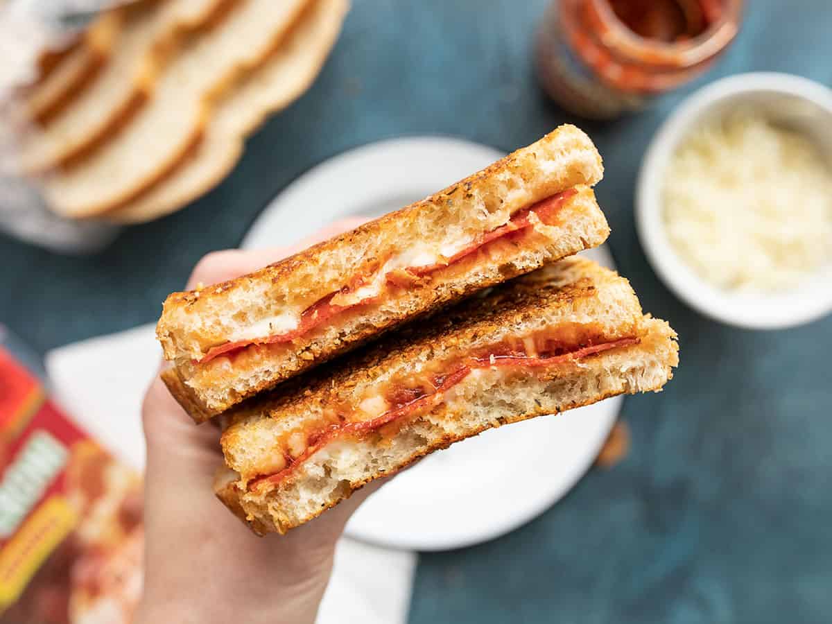 cut open pizza melt being held close to the camera