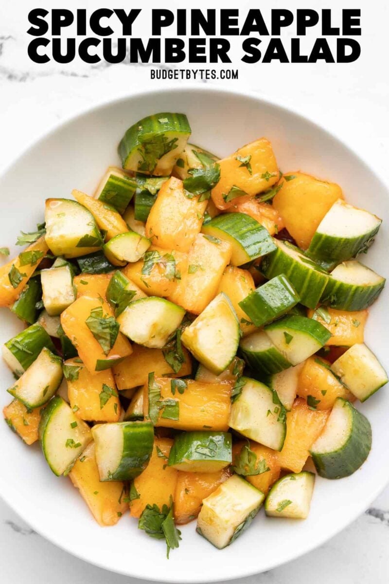 overhead view of a bowl full of pineapple cucumber salad, title text at the top