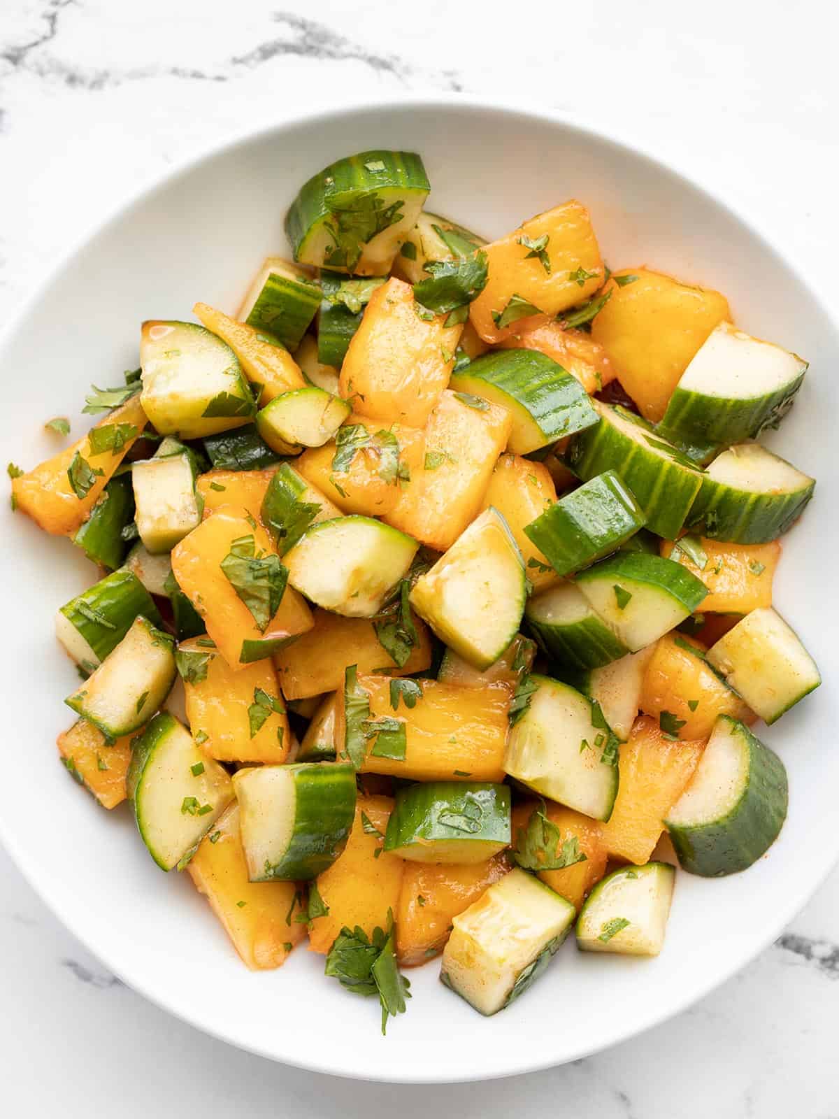 Close up overhead view of a bowl of spicy pineapple cucumber salad