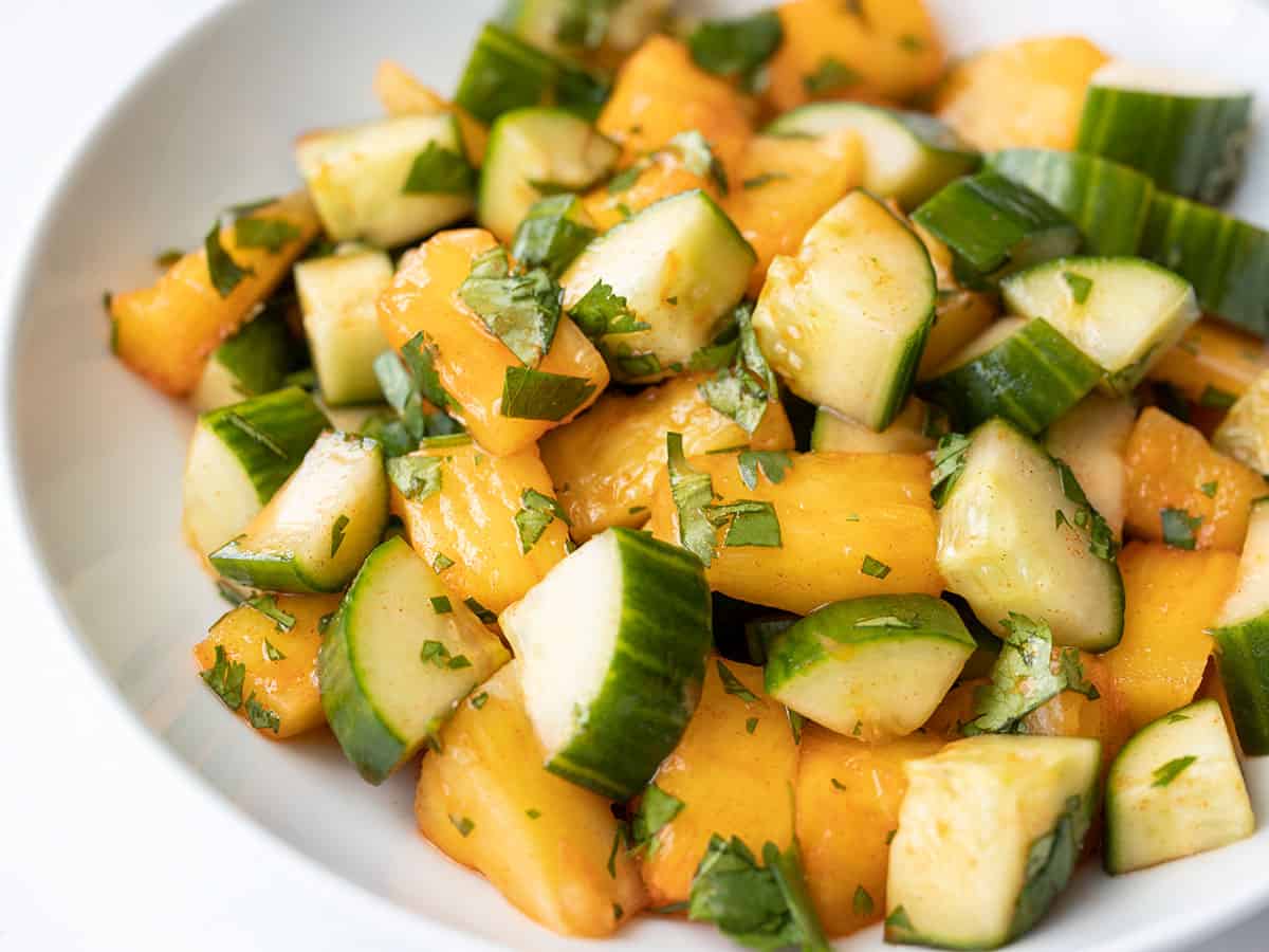 Side view of spicy pineapple cucumber salad in a bowl