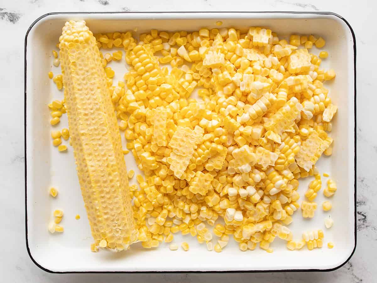 corn kernels sliced off an ear of corn in a baking tray