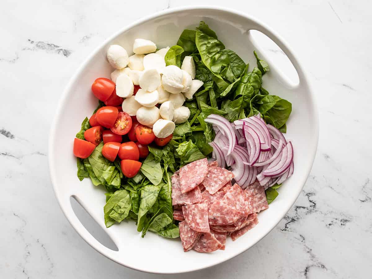 salami, onions, mozzarella, and tomatoes added to the salad bowl