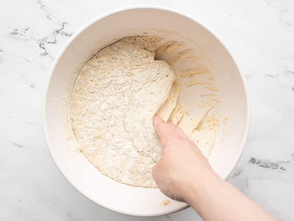 Risen dough being scraped from the sides of the bowl