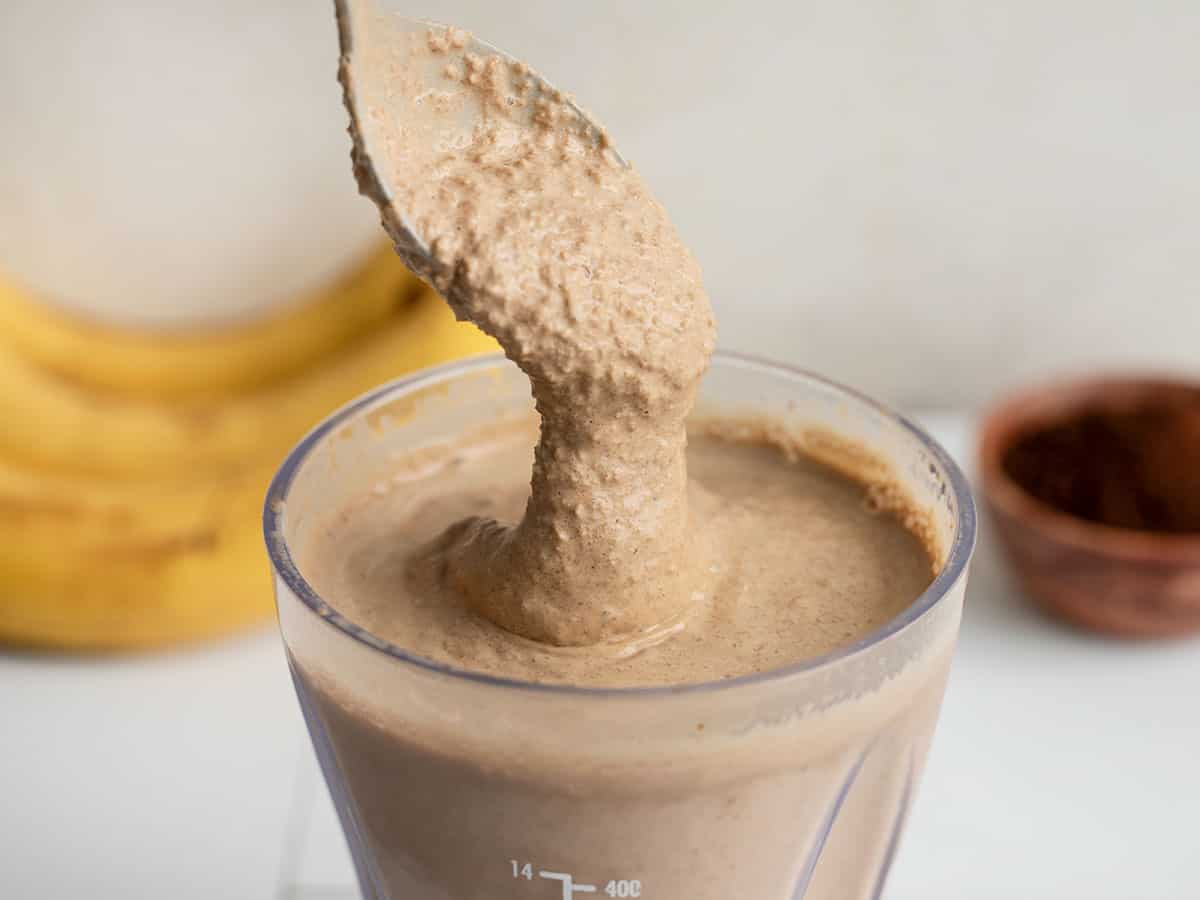 chocolate coffee breakfast smoothie dripping off a spoon into the blender cup