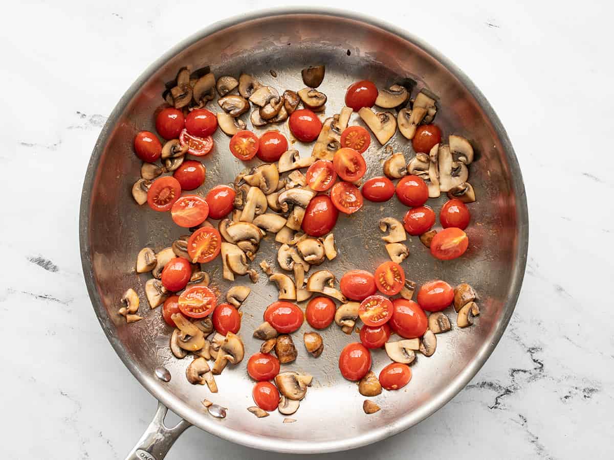 Tomatoes added to the skillet with mushrooms