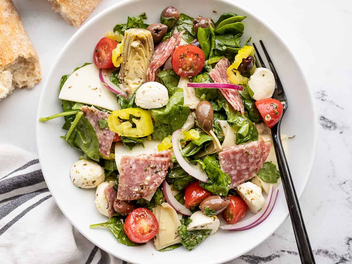 Close up of antipasto salad in a bowl with a fork