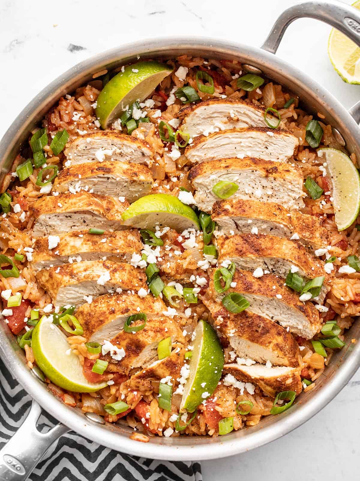 chipotle lime chicken and rice in the skillet, garnished with lime wedges