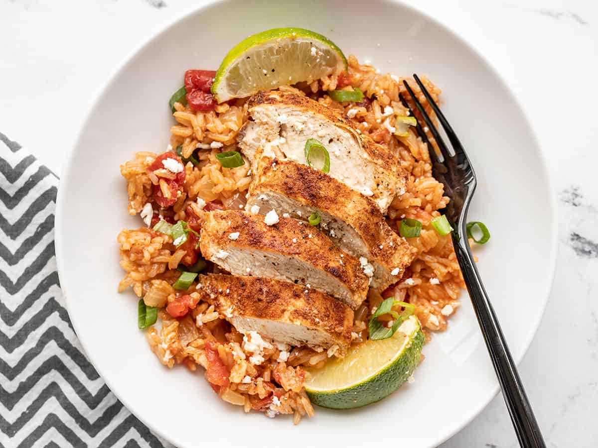 overhead view of a bowl with chipotle lime chicken and rice and a fork