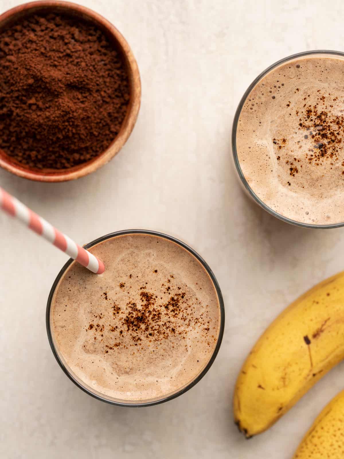 Overhead view of two glasses full of coffee chocolate breakfast smoothies