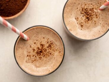 overhead view of two glasses full of chocolate coffee breakfast smoothie with straws