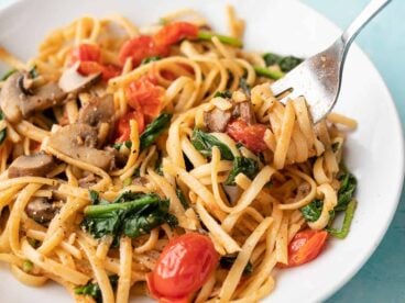 Side view of quick veggie pasta in a bowl twirled around a fork