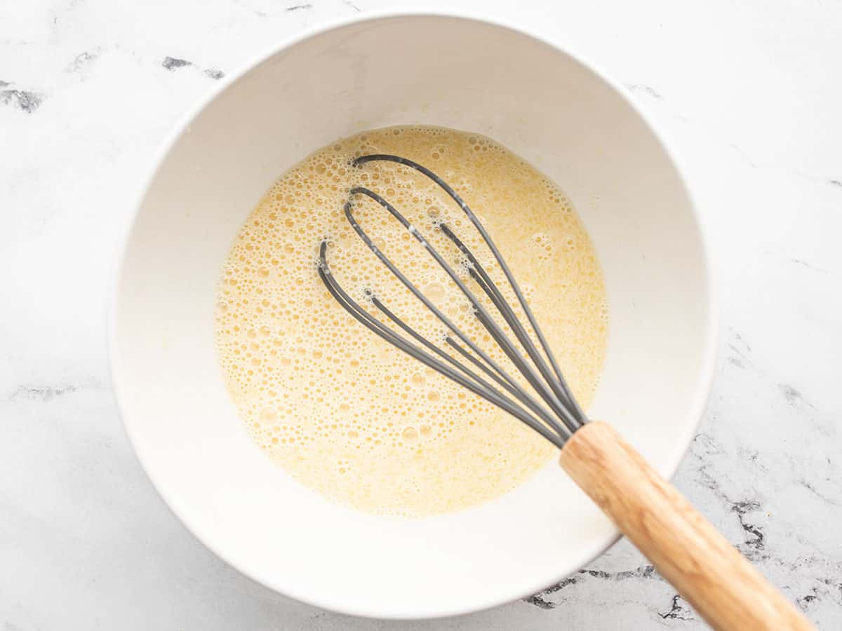 whisked wet ingredients in a bowl with a whisk