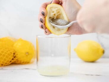 A lemon being reamed with a spoon