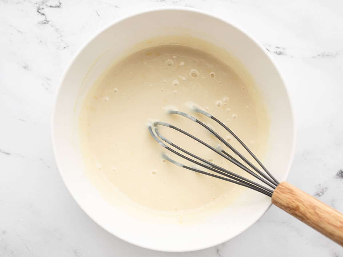 sweetened condensed milk with lemon in a bowl with a whisk