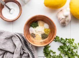 ranch seasoning mix ingredients in a wooden bowl with ingredients on the sides